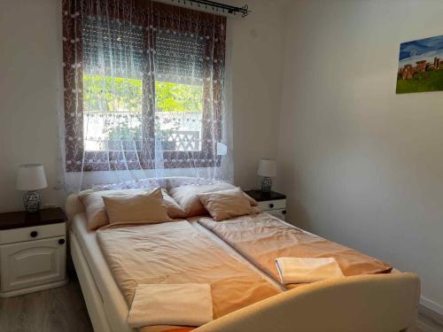 a large bed in a bedroom with a window at Apartment in Balatonbereny - Balaton 18046 in Balatonberény
