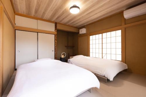 two beds in a room with two windows at rinne 那須 Garden 3 in Nasu