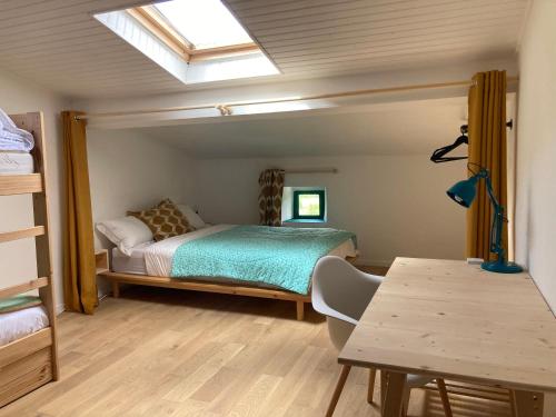 a bedroom with a bed and a table and a skylight at Home in Drome provençale in Vesc