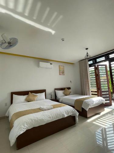 a bedroom with two beds and a window at OThuy's House in Hue in Hue