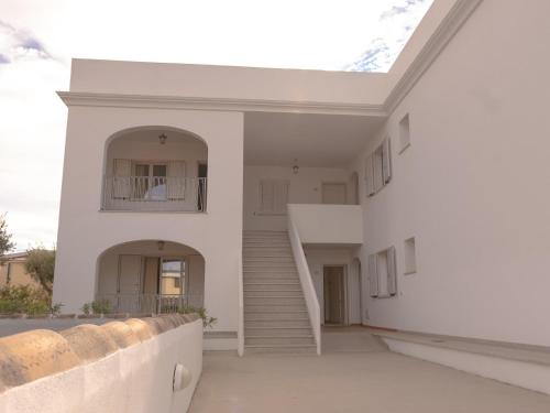 a white house with stairs and a stair case at Le Residence del Golfo Orosei in Orosei
