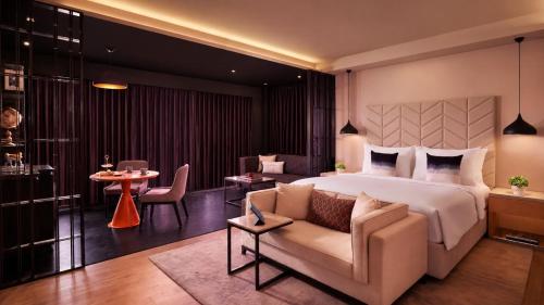 a hotel room with a bed and a couch at Hyatt Centric Juhu Mumbai in Mumbai