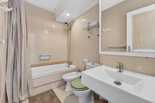 a bathroom with a sink and a toilet and a bath tub at Bella vista in Playa Fañabe