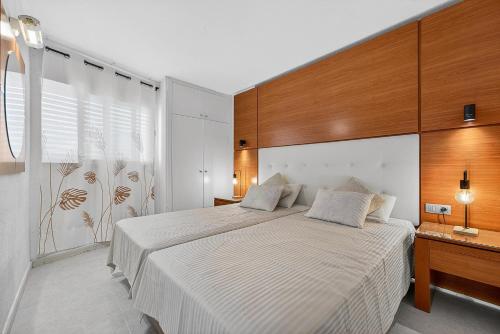 a bedroom with a large white bed and a window at Bella vista in Playa Fañabe