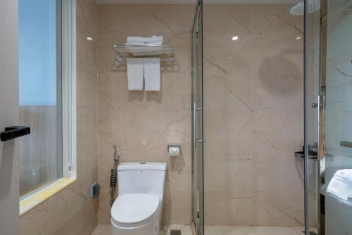 a bathroom with a toilet and a glass shower at Hùng Vương Hotel - Stay 24h in Móng Cái