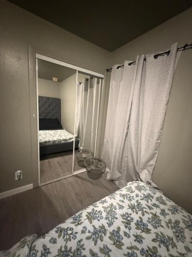 a bedroom with a bed with a window and a mirror at Alvin Relax in El Cajon