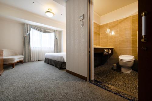 a hotel room with a toilet and a bed at KOKO HOTEL Osaka Shinsaibashi in Osaka