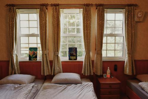 two beds in a room with two windows at Echoland Madarao エコーランド斑尾 All en-suite rooms & a free 3-minute shuttle to the ski resort in Madarao Kogen