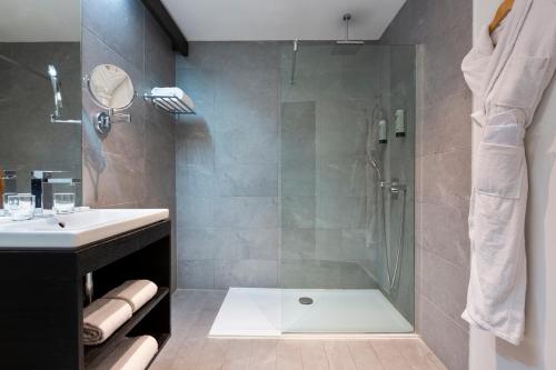 a bathroom with a shower and a sink at Moulin de Vernègues Hôtel & Spa in Mallemort