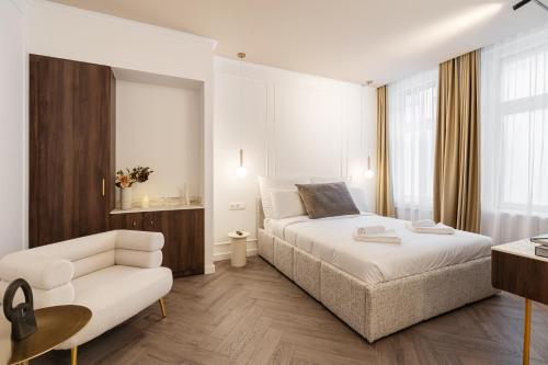 a bedroom with a white bed and a couch at La Maison Parliament by BQA in Budapest