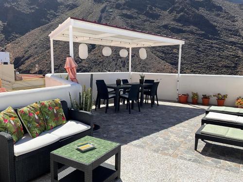 a patio with a table and chairs and a white canopy at Casa Mussa in Valle Gran Rey