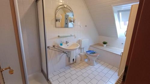 a bathroom with a shower and a sink and a toilet at Kaptains Koje in Wittmund