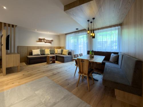 a living room with a table and a couch at Weingut Santer Apartments in Mühlbach