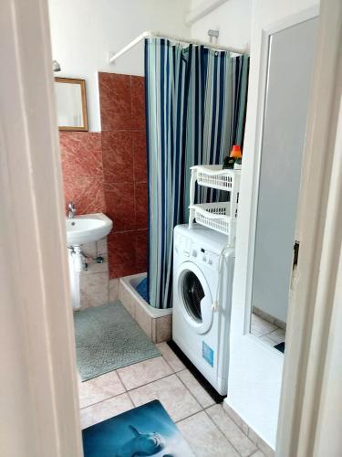 a bathroom with a washing machine in a bathroom at Átutazó Apartman in Nyíregyháza