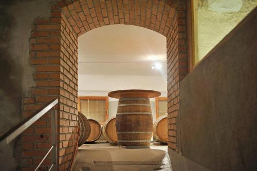 a brick hallway with wooden barrels in a room at Weingut Santer Apartments in Mühlbach