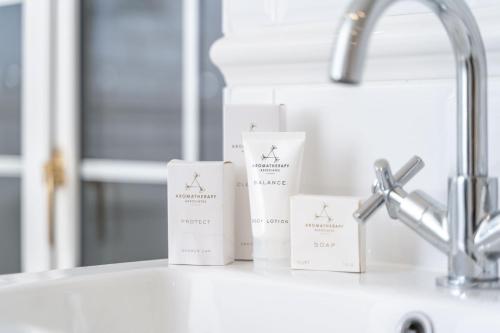 three boxes ofodorizers sitting on a counter next to a sink at Monkey Island Estate - Small Luxury Hotels of the World in Windsor