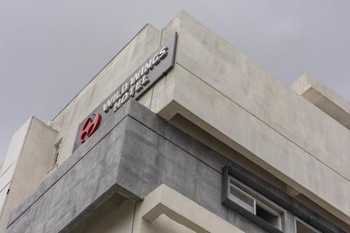 a building with a sign on the top of it at Wild Wings Hotel Narsingi in Hyderabad