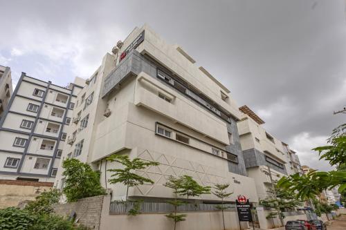 a tall white building with trees in front of it at Wild Wings Hotel Narsingi in Hyderabad