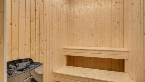 a wooden sauna with a bench and a trash can at Villavilla 604 - Gjerrild, Østjylland in Grenå