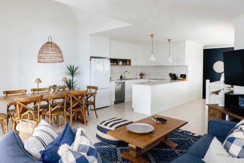 a living room with a blue couch and a table at La Ronde Three - Unit 3 - Oceanstays in Yamba