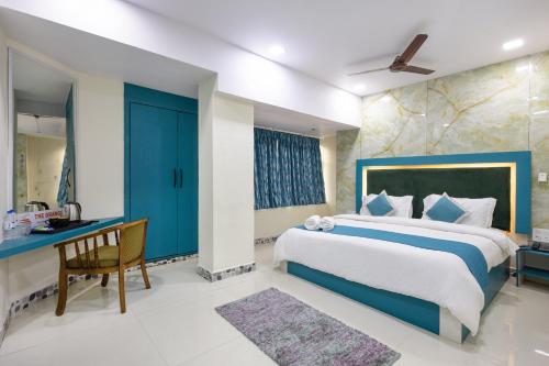a bedroom with a large bed and a desk at The Orange Hotel in Visakhapatnam