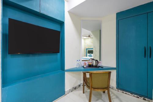 a room with blue cabinets and a table with a television at The Orange Hotel in Visakhapatnam