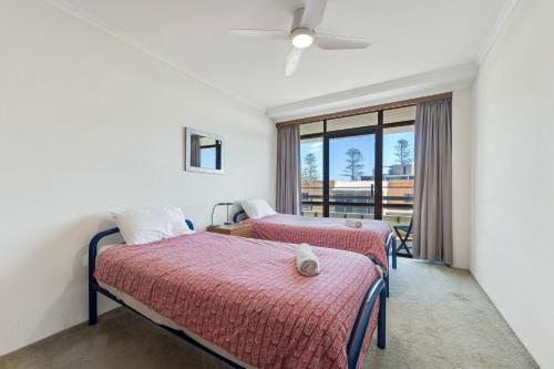 two beds in a room with a window at Akuna 14, 6 Joffre Street in Port Macquarie