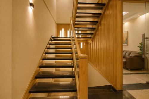 a wooden staircase in a living room with a couch at Hotel Elite La Prizm Near Zirakpur Bus Stand in Zirakpur