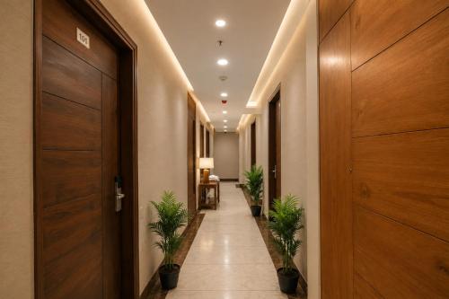 a corridor with potted plants in a hallway at Hotel Elite La Prizm Near Zirakpur Bus Stand in Zirakpur