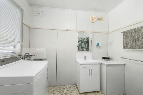 a white bathroom with two sinks and a tub at Almare, 7 Gowing Street in Crescent Head