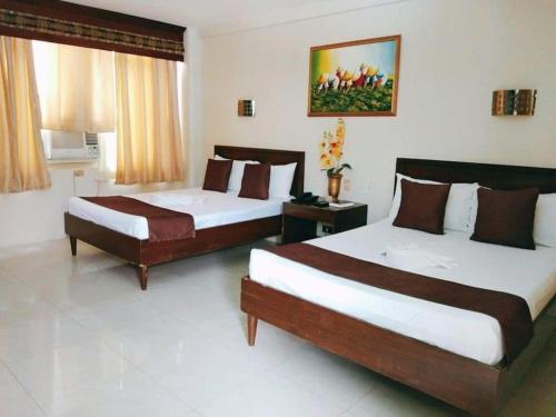 two beds in a hotel room with two beds sidx sidx sidx at Splash Oasis Resort & Hotel in Forestry