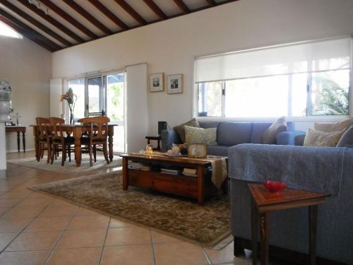 a living room with a blue couch and a table at Bellevue Holiday House Crescent Head in Crescent Head