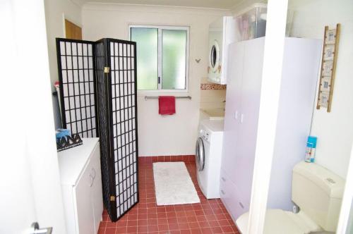a small bathroom with a toilet and a refrigerator at Bellevue Holiday House Crescent Head in Crescent Head
