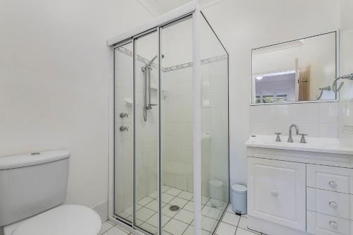 a bathroom with a shower and a toilet and a sink at Breakers 2 in Crescent Head