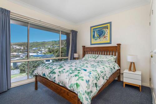 a bedroom with a bed and a large window at Breakers 2 in Crescent Head