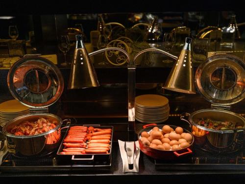 a buffet with plates and bowls of food on a table at Mercure Budapest Korona in Budapest