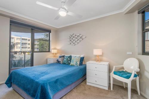 a bedroom with a bed and a chair and a window at Flightdeck 301, Clarence Street in Port Macquarie