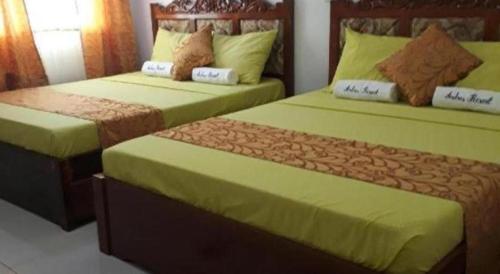 two beds sitting next to each other in a bedroom at Andres Resort in Nabas