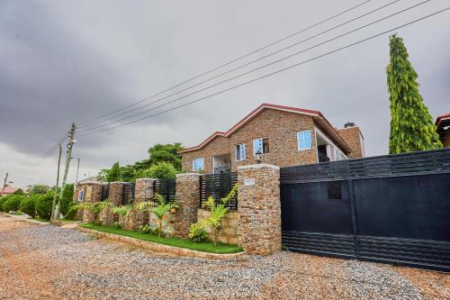 a brick house with a black fence and a driveway at Douglas Luxury Apartments - Douglas Court in Trofwi