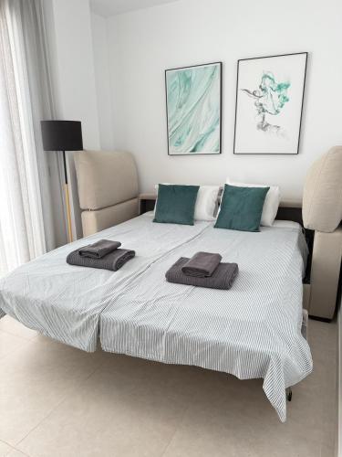 a bedroom with a large bed with towels on it at Seafront 2B Apartment with Pool, Spa & Gym Torrox in Torrox