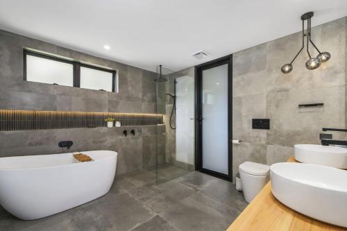 a bathroom with two sinks and a tub at La Mer, 19 Dulconghi Street in Crescent Head