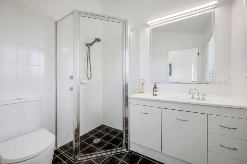 a bathroom with a shower and a toilet and a sink at Lighthouse Beach Luxury in Port Macquarie