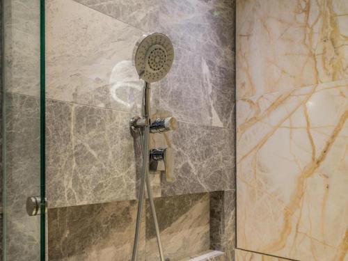 a shower with a shower head in a bathroom at Ovolo Central in Hong Kong