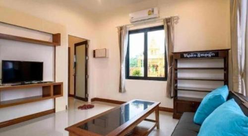 a living room with a couch and a window at Cindia Resort in Phun Phin