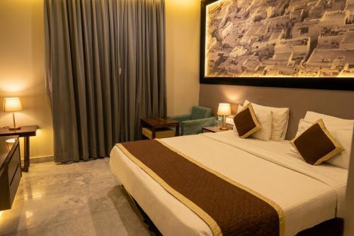 a hotel room with a bed and a chair at Hotel Las Vegas in Jaipur