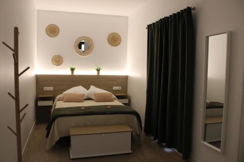 a bedroom with a bed and a mirror at Los Llanos Loft & Suites in Manzanilla