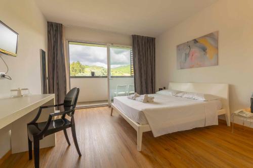 a bedroom with a bed and a desk and a window at Terme Di Venturina - Toscana in Venturina Terme