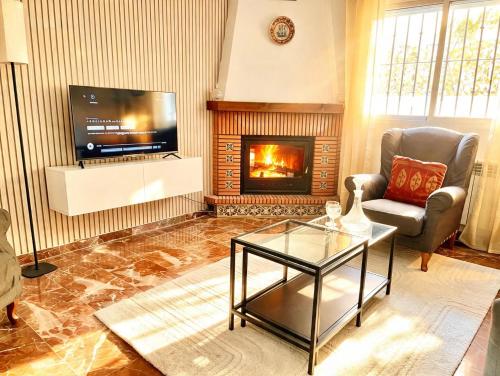 a living room with a fireplace and a tv at Casa rural Lomalinda in Granada