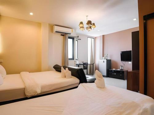 a bedroom with a large bed and a living room at Debua Mahasarakham in Maha Sarakham