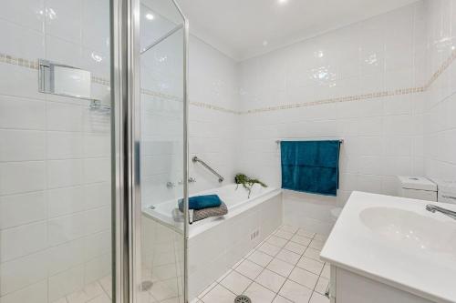 a white bathroom with a tub and a sink at Pippies, your water view escape in North Haven